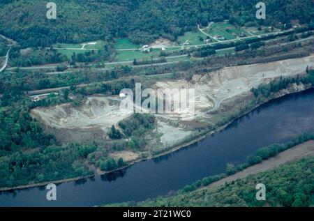Aus der Vogelperspektive eines aktiven Sand- und Kiesbergbaus in der Nähe der Städte Hartland und Plainfield, Vermont, mit Ausgrabungsgruben, freiliegendem Boden und Sedimentabfluss, der in einen nahegelegenen Fluss mündet. Stockfoto