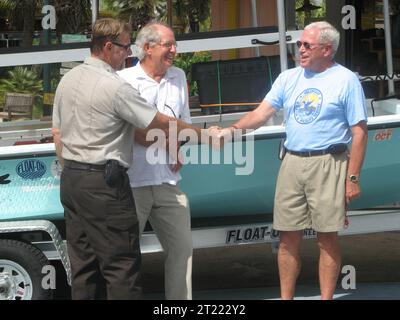 Gulf Shores, Ala - 19. Juli 2010: Der Kapitän des U.S. Fish and Wildlife Service Bob Quarles nimmt die Schlüssel zum Sallow Water Attention Terminal (SWAT)-Boot von Freunden von Bon Secour Präsident Ralph Gilges entgegen, während Jimbo Meador von Dragonfly Boatworks auf der Suche nach anderen Themen: Boote; Deepwater Horizon Ölpest. Lage: Alabama. Fish and Wildlife Service Site: BON SECOUR NATIONAL WILDLIFE REFUGE. Stockfoto