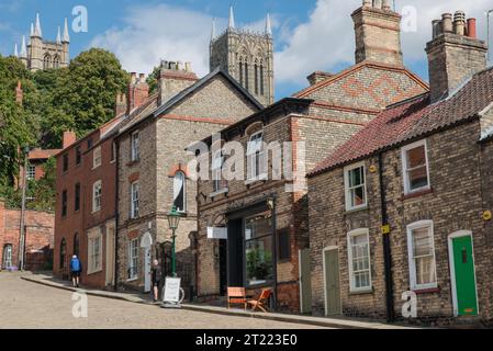 Menschen, die den steilen Hügel hinauflaufen, der zur Lincoln Cathedra in der Stadt Lincoln, Lincolnshire, England führt Stockfoto