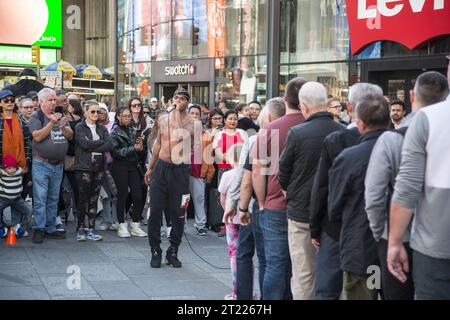 Straßenakrobaten und Entertainer ziehen regelmäßig große Menschenmassen in der Fußgängerzone Times Square am Broadway an. Stockfoto