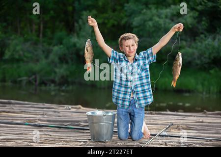 Glücklicher Fischer mit einem Fang. Der Fischer hat einen Karpfen gefangen. Stockfoto