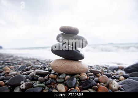 Meeressteine stapeln sich übereinander vor dem Hintergrund des Meeres. Kieselstrand. Stockfoto