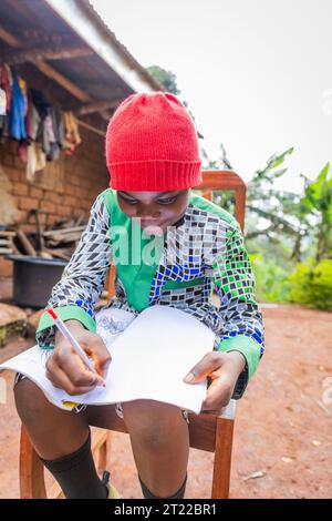 Ein afrikanisches Kind macht Hausaufgaben im Dorf, Bildung in Kamerun Stockfoto