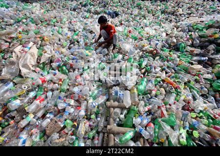 Dhaka, Wari, Bangladesch. Oktober 2023. Mitarbeiter recyceln leere Haustierflaschen, um sie in einer Recyclingfabrik für Kunststoffflaschen wiederzuverwenden. Am 15. Oktober 2023 werden in Dhaka, Bangladesch, fast alle Saft-, Getränke- und Trinkwasserprodukte in Plastikflaschen verpackt. Diese Flaschen werden von Straßen, Geschäften und Häusern gesammelt. (Kreditbild: © Habibur Rahman/ZUMA Press Wire) NUR REDAKTIONELLE VERWENDUNG! Nicht für kommerzielle ZWECKE! Stockfoto