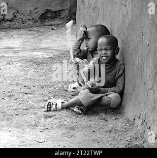 Stammeskinder von Maasai Mara spielen in ihrem Dorf Stockfoto