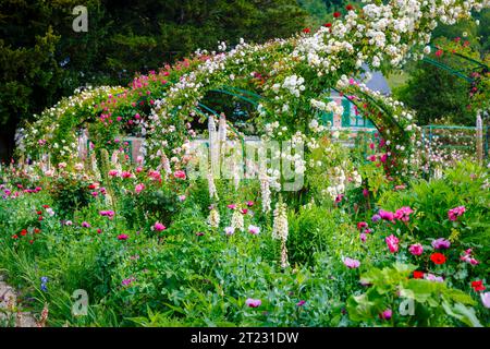 Rosenbögen und farbenfrohe Sommerblumenränder in Giverny, dem Garten des französischen impressionistischen Malers Claude Monet, Normandie, Nordfrankreich Stockfoto