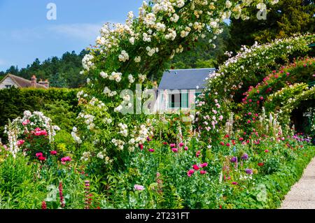 Rosenbögen und farbenfrohe Sommerblumenränder in Giverny, dem Garten des französischen impressionistischen Malers Claude Monet, Normandie, Nordfrankreich Stockfoto