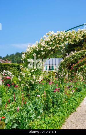 Rosenbögen und farbenfrohe Sommerblumenränder in Giverny, dem Garten des französischen impressionistischen Malers Claude Monet, Normandie, Nordfrankreich Stockfoto