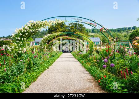 Rosenbögen und farbenfrohe Sommerblumenränder in Giverny, dem Garten des französischen impressionistischen Malers Claude Monet, Normandie, Nordfrankreich Stockfoto