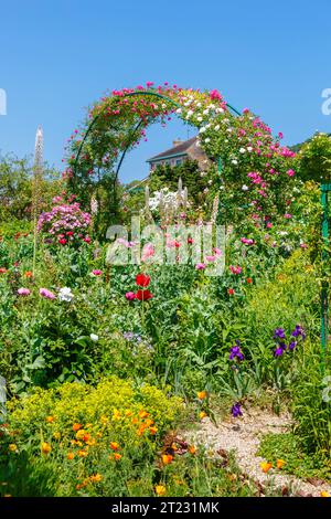 Rosenbögen und farbenfrohe Sommerblumenränder in Giverny, dem Garten des französischen impressionistischen Malers Claude Monet, Normandie, Nordfrankreich Stockfoto