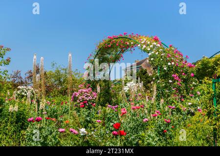 Rosenbögen und farbenfrohe Sommerblumenränder in Giverny, dem Garten des französischen impressionistischen Malers Claude Monet, Normandie, Nordfrankreich Stockfoto