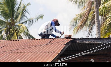 Pinrang Indonesia, 16. Oktober 2023: Landschaftsfotografie, Schreiner ersetzen ein altes Blechdach in Asien Indonesien Stockfoto