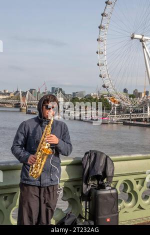 Busker spielt Saxophon auf der Westminster Bridge, London Stockfoto