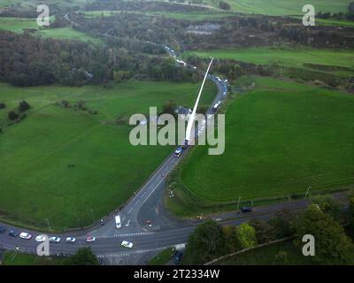 Selkirk, Großbritannien. Oktober 2023. Ein Windturbinenschaufel auf dem Weg zu einer neuen Anlage in der Nähe von Hawick, ein Verkehrskonvoi machte die Reise von einem Haltepunkt auf der A68 bei St Boswells nach Selkirk auf der A699, dann navigierte er an einer ungünstigen Kreuzung an der A7 Selkirk, auf der A7 nach Süden hält sie über Nacht an, bevor sie weiter zum Ziel am Windpark Pines Burn geht. Es handelt sich um ein 36-MW-Projekt ohne Subventionen für Onshore-Windenergie, das sich auf dem Harwood Estate in der Nähe der Bonchester Bridge und Hawick in den schottischen Grenzen befindet. (Quelle: Rob Gray/Alamy Live News Stockfoto