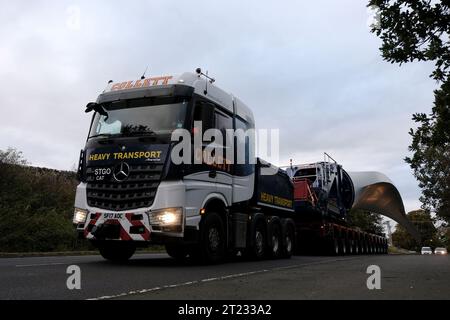 Selkirk, Großbritannien. Oktober 2023. Ein Windturbinenschaufel auf dem Weg zu einer neuen Anlage in der Nähe von Hawick, ein Verkehrskonvoi machte die Reise von einem Haltepunkt auf der A68 bei St Boswells nach Selkirk auf der A699, dann navigierte er an einer ungünstigen Kreuzung an der A7 Selkirk, auf der A7 nach Süden hält sie über Nacht an, bevor sie weiter zum Ziel am Windpark Pines Burn geht. Es handelt sich um ein 36-MW-Projekt ohne Subventionen für Onshore-Windenergie, das sich auf dem Harwood Estate in der Nähe der Bonchester Bridge und Hawick in den schottischen Grenzen befindet. (Quelle: Rob Gray/Alamy Live News Stockfoto