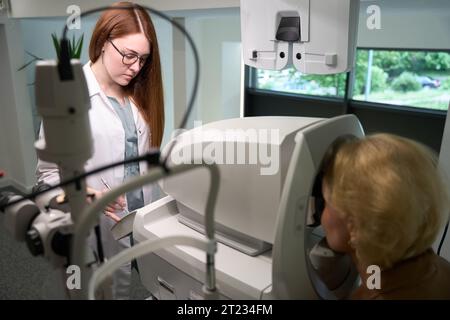 Blonde Frau in lässiger Kleidung bei einem Augenarzt-Termin Stockfoto