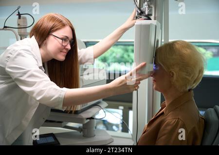 Eine hübsche Augenärztin benutzt ein Dioptermeter in ihrer Arbeit Stockfoto
