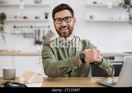 Mobile Webkamera-Ansicht eines fröhlichen Mannes in Brille, der neue Smart Watch und Video-Blog anprobiert. Technologie-Blogger macht Online-Rezension von Mo Stockfoto