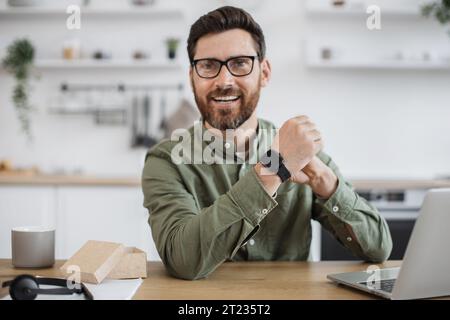 Mobile Webkamera-Ansicht eines fröhlichen Mannes in Brille, der neue Smart Watch und Video-Blog anprobiert. Technologie-Blogger macht Online-Rezension von Mo Stockfoto