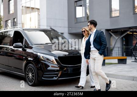 Geschäftsleute laufen zu Fuß zum Taxi im Minibus Stockfoto
