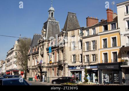 Frankreich, Fontainebleau, Rue Grande: Leute, die an einer Bushaltestelle vor dem „mairie“ (Rathaus) aus dem 18. Jahrhundert warten. Stockfoto