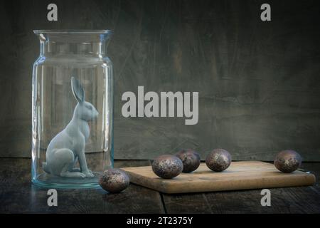 Schöne Kaninchen im Glasbehälter mit Ostereiern. Ostertierkaninchen Konzept. Stillleben-Bild Stockfoto