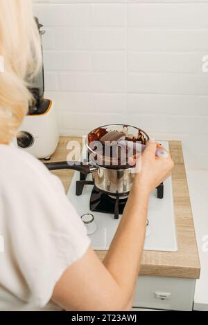 Der Konditor mischt geschmolzene Schokolade. Nahaufnahme. Stockfoto