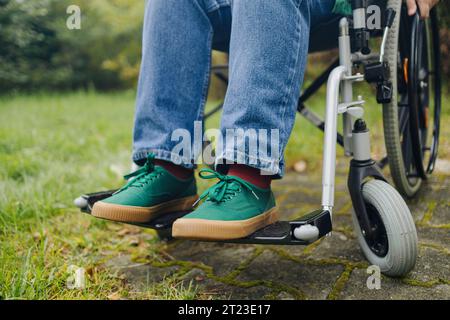 Behinderte Frau sitzt im Stadtpark auf Rollstuhl. Stockfoto