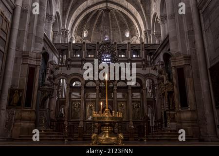 Die Kerzen und Ikonostase am griechisch-orthodoxen Katholikon in der Grabeskirche in der Altstadt von Jerusalem, Israel. Stockfoto