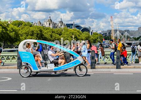 Nicht identifizierte Menschen auf Fahrradrikschas in London. Fahrradrikschas sind in großen Städten weltweit weit verbreitet und werden von Passagieren angemietet Stockfoto