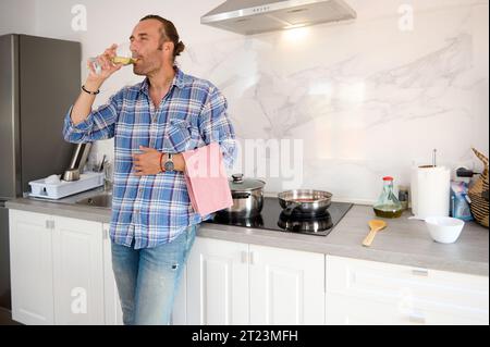Porträt des jungen Erwachsenen, mittleren Alters, mittelerwachsenen Mannes in den 40er Jahren, Wein zu Hause trinken, Weinglas halten. Experte für Weinproben. Stockfoto