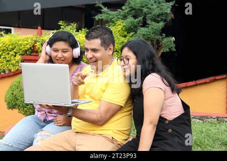 Dunkelhäutige Latino-Papa und -Töchter nutzen ihr Notebook zusammen und verbringen Zeit mit Spielen, Hausaufgaben, Lernen und Videos Stockfoto