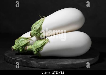 Drei frische weiße Auberginen auf schwarzem Tisch Stockfoto