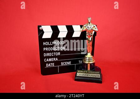 oscar-Preis und Filmklappertafel auf rotem Hintergrund Stockfoto