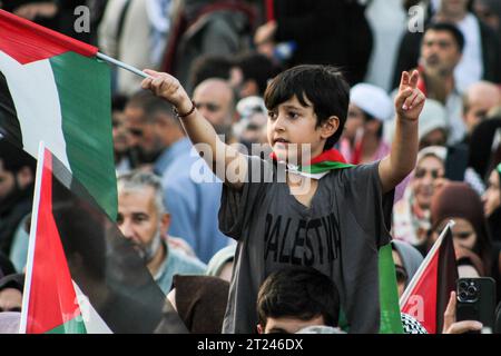 Istanbul, Türkei. Oktober 2023. Ein Kind hebt während eines demonstrationsmarsches in Solidarität mit dem palästinensischen Volk mit der einen Hand ein Siegeszeichen und in der anderen die palästinensische Flagge. (Foto: Muhmmad Al-Najjar/SOPA Images/SIPA USA) Credit: SIPA USA/Alamy Live News Stockfoto