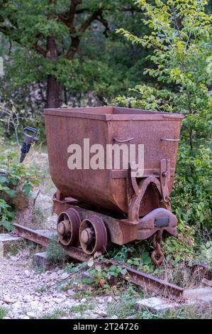 Alter rostiger Bergwerkswagen auf einer Schiene. Dekoration im Park. Stockfoto