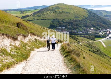 Lulworth Cove südwestlicher Küstenpfad, älteres Paar geht in Richtung Lulworth Cove steiler Abfahrt, Dorset, England, UK, September 2023 Stockfoto