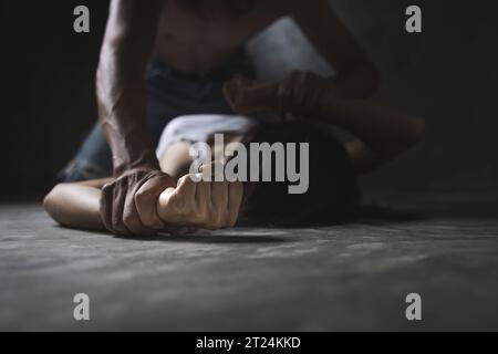 Die Faust eines Mannes greift eine Frau an. Geschlagen und vergewaltigt in der Ecke, Gewaltkonzept, häusliche Gewalt. Stockfoto