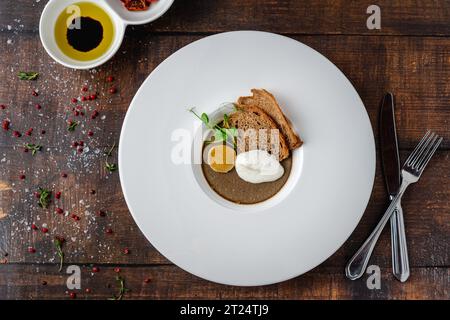 Crostini Fegatini auf weißem Porzellanteller auf Holztisch Stockfoto