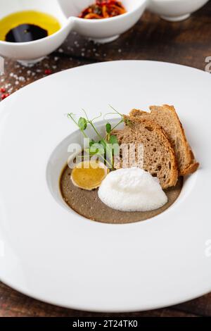 Crostini Fegatini auf weißem Porzellanteller auf Holztisch Stockfoto