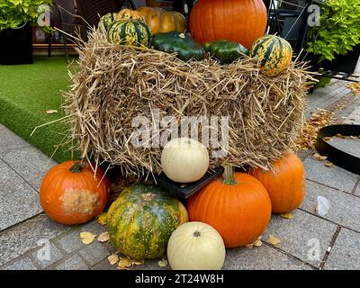 Orangefarbene Kürbisse neben einer Heu-Garbe Stockfoto