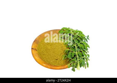 Moringa-Pulver in einer Holzschale mit Moringa-Blättern auf weißem Hintergrund. Stockfoto