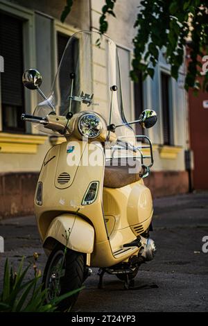 Gelbes Vespa Scooter Motorrad vor dem Haus Stockfoto
