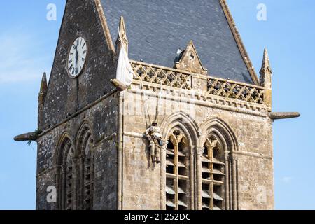 Nahaufnahme der Fallschirmspringerpuppe, die am Kirchturm der Kirche von Sainte-Mere-Eglise hing, als Hommage an das, was der Privatmann John Steele am D Day durchmachte. Stockfoto