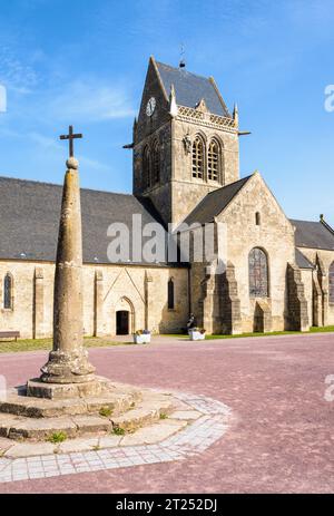 Calvary und Sainte-Mere-Eglise's Kirche mit einer Fallschirmjäger-Dummy hing am Glockenturm als Hommage an das, was der Privatmann John Steele am D Day durchmachte. Stockfoto