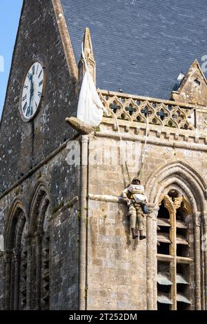 Nahaufnahme der Fallschirmspringerpuppe, die am Kirchturm der Kirche von Sainte-Mere-Eglise hing, als Hommage an das, was der Privatmann John Steele am D Day durchmachte. Stockfoto