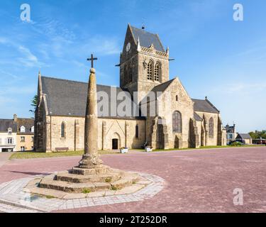 Calvary und Sainte-Mere-Eglise's Kirche mit einer Fallschirmjäger-Dummy hing am Glockenturm als Hommage an das, was der Privatmann John Steele am D Day durchmachte. Stockfoto