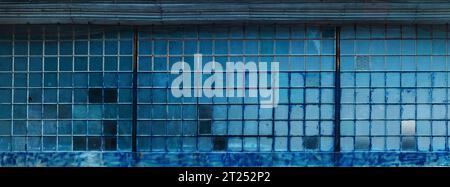 Gitterfenster des alten Fabrikgebäudes mit Glasbruch als industrieller Hintergrund Stockfoto