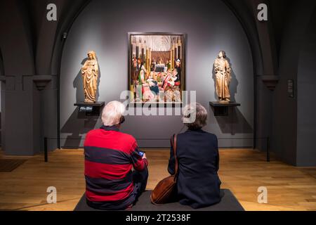 Leute hören Kommentare und schauen sich die Heilige Verwandtschaft an, von der Werkstatt von Geertgen tot Sint Jans, von 1495 im Rijksmuseum, Amsterdam. Stockfoto