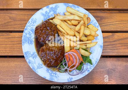 Blick von oben auf traditionelle bayerische Fleischbällchen, Pommes Frites, Salat und Sauce Stockfoto